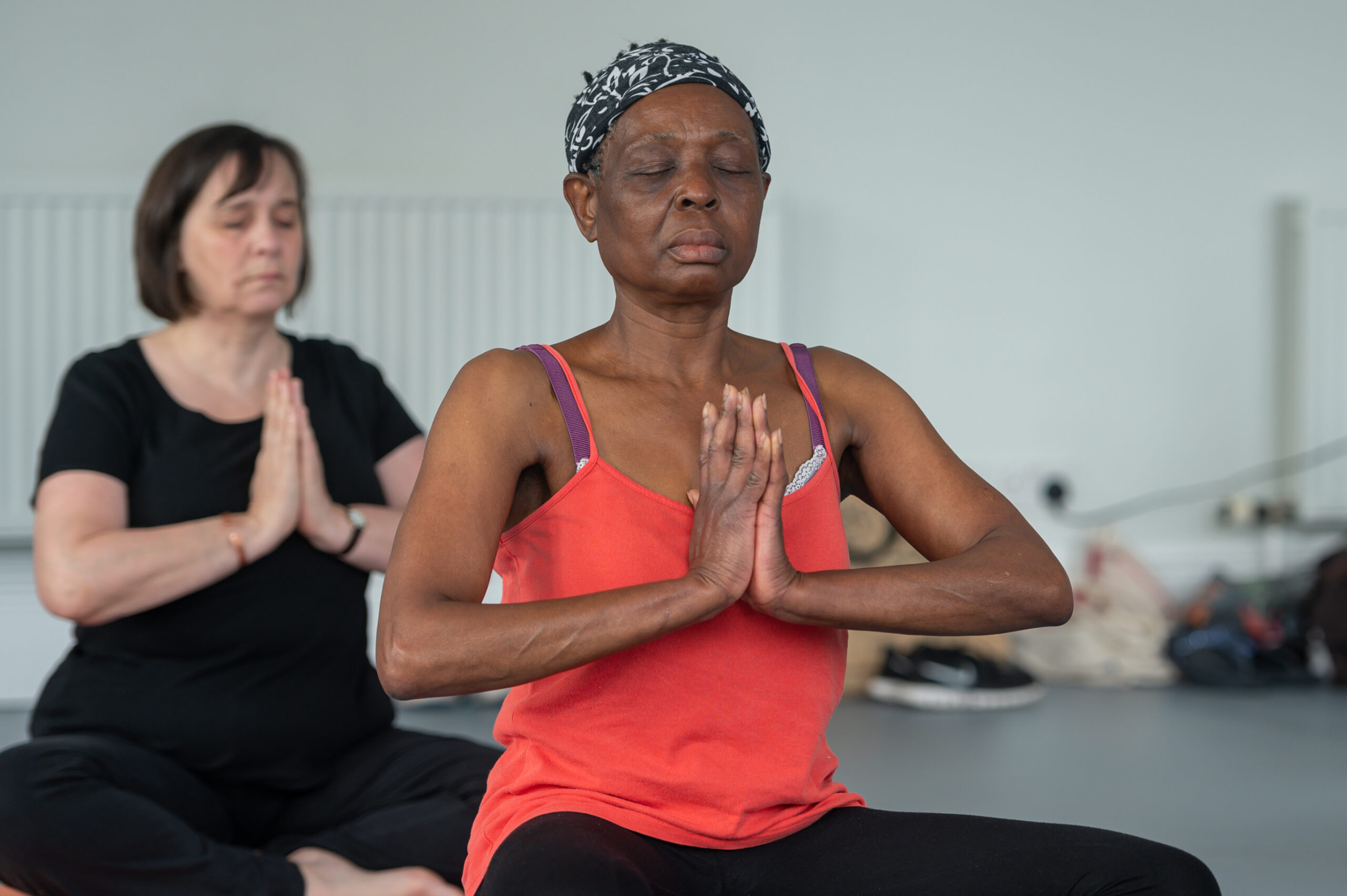 Two women participating in yoga class in the workplace